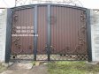 Розпашні ворота з профлиста та бетонним парканом